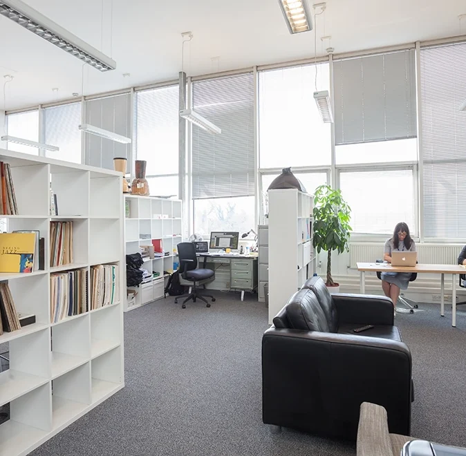 A spacious office with desks, seating area and bookshelves